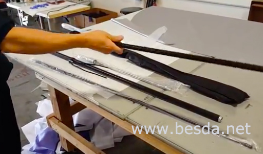 Feather flag kit components laid out on a workshop bench: pole sections and carry bag