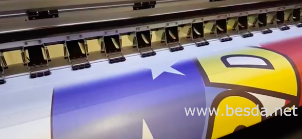Dye-sublimation printer applying colour to beach flag fabric on the production line