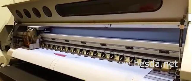 Dye-sublimation printer running mirrored artwork onto transfer paper for a custom beach flag order